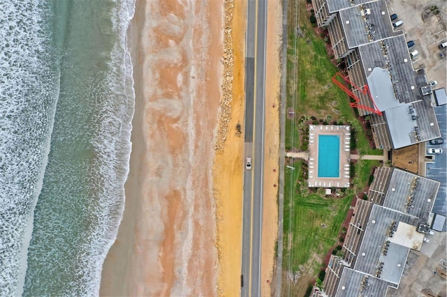 birds eye view of property featuring a water view and a beach view