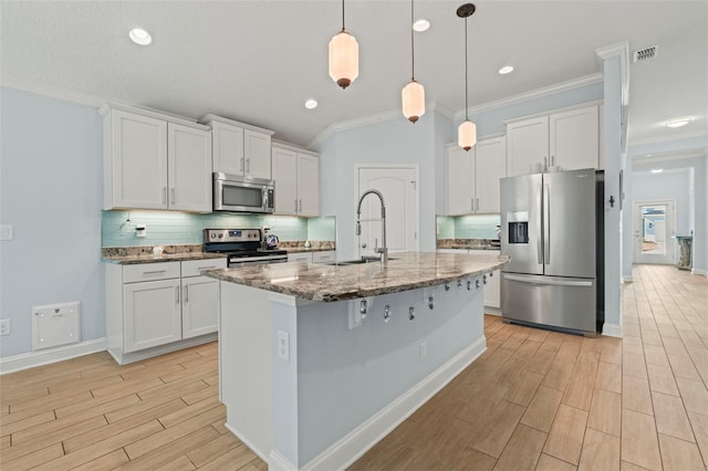 kitchen with visible vents, decorative backsplash, stainless steel appliances, wood finish floors, and a sink