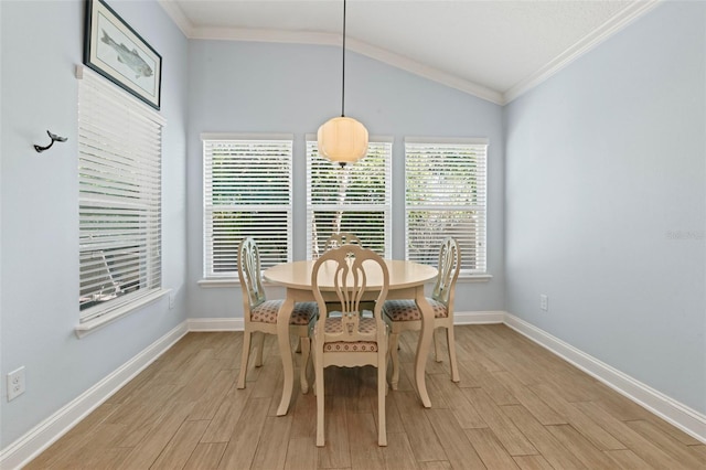 dining space featuring light wood-type flooring, ornamental molding, and vaulted ceiling