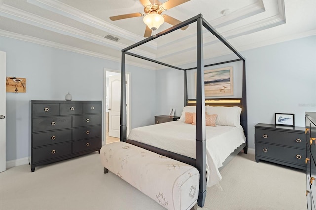 bedroom with visible vents, a raised ceiling, crown molding, and light colored carpet