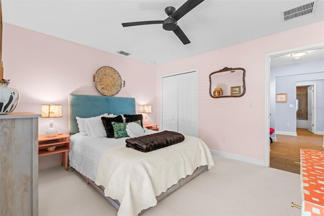 carpeted bedroom with ceiling fan, a closet, visible vents, and baseboards