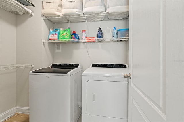 laundry area with laundry area, washer and clothes dryer, and baseboards