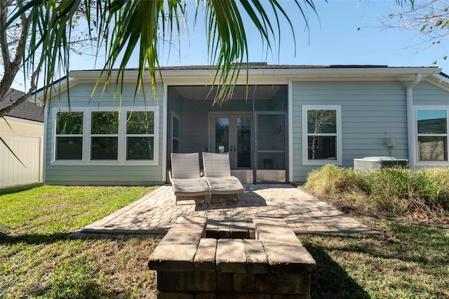 back of property featuring a lawn, a patio, a sunroom, fence, and cooling unit