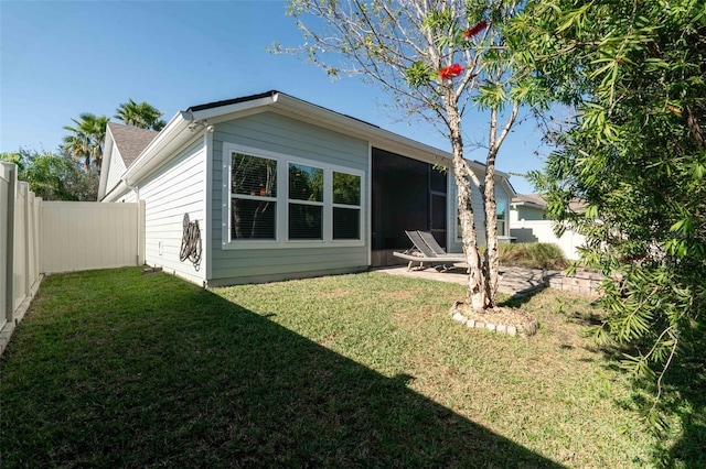 rear view of house featuring a lawn, a patio area, and a fenced backyard