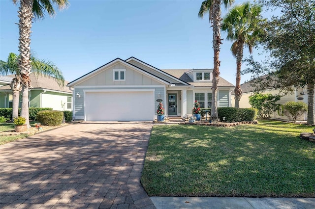 view of front facade featuring board and batten siding, a front yard, decorative driveway, and a garage