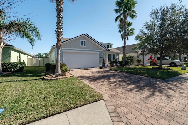 ranch-style home with board and batten siding, a front yard, decorative driveway, and an attached garage