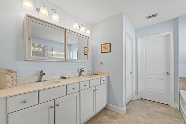 bathroom with double vanity, a tub, baseboards, and a sink