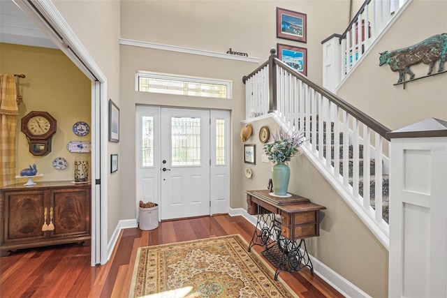 foyer entrance with dark wood-type flooring and a high ceiling