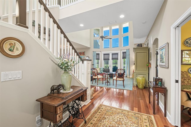 interior space featuring french doors, a towering ceiling, and hardwood / wood-style floors