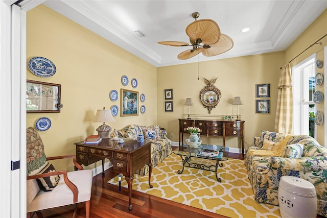 living room with wood-type flooring, a tray ceiling, ceiling fan, and crown molding