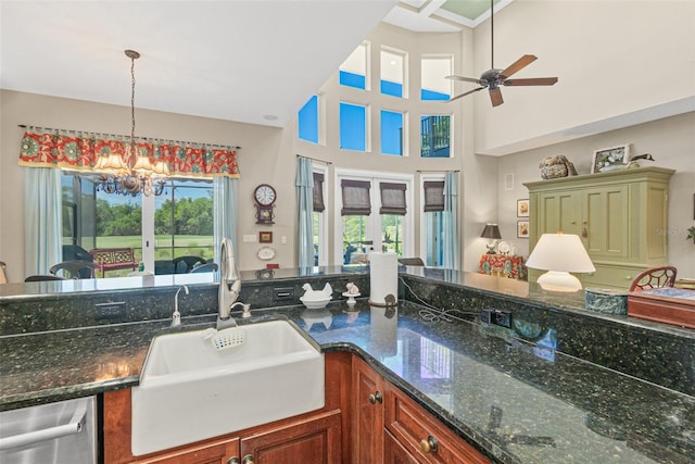 kitchen with decorative light fixtures, sink, dark stone counters, and french doors