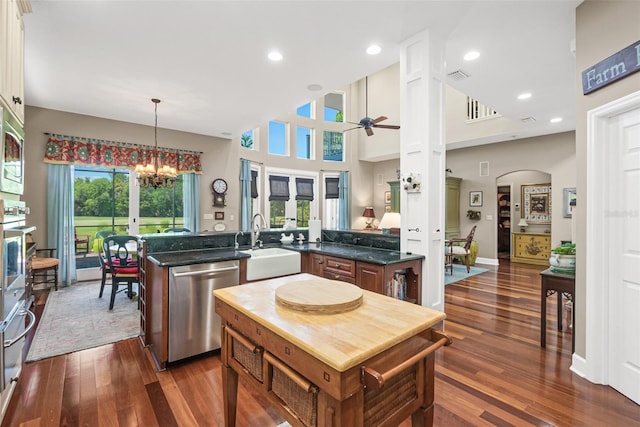 kitchen featuring ceiling fan with notable chandelier, sink, hanging light fixtures, appliances with stainless steel finishes, and kitchen peninsula