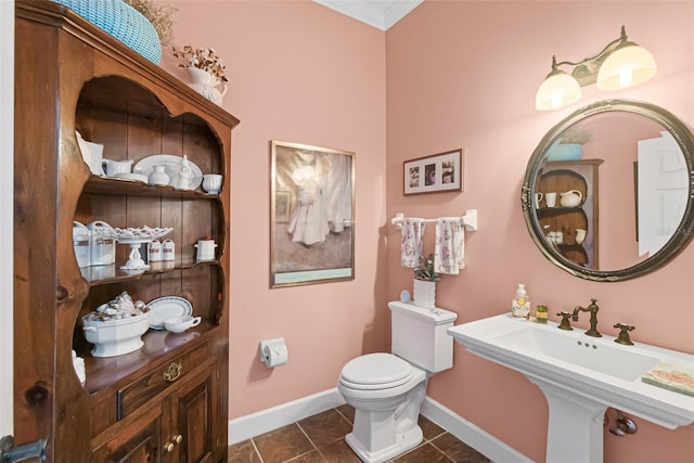 bathroom with toilet, tile patterned floors, ornamental molding, and sink