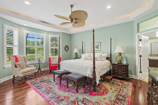 bedroom featuring ceiling fan, dark hardwood / wood-style floors, crown molding, and a tray ceiling