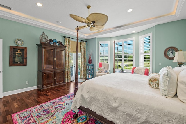 bedroom with a tray ceiling, ceiling fan, dark hardwood / wood-style flooring, and crown molding