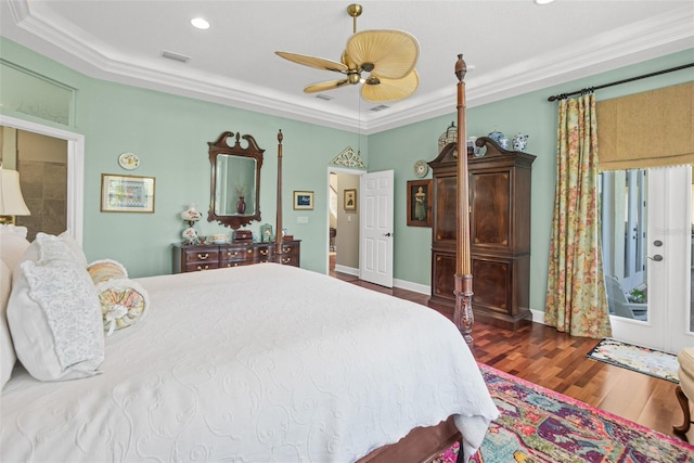 bedroom featuring dark hardwood / wood-style floors, ceiling fan, crown molding, and a tray ceiling