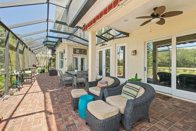 view of patio featuring a lanai, ceiling fan, and french doors