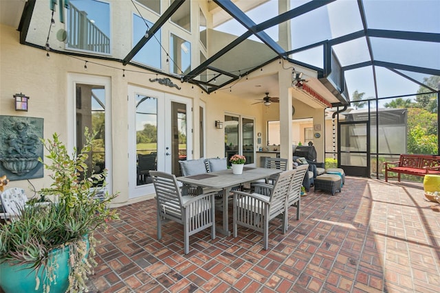 sunroom with ceiling fan, a wealth of natural light, and french doors