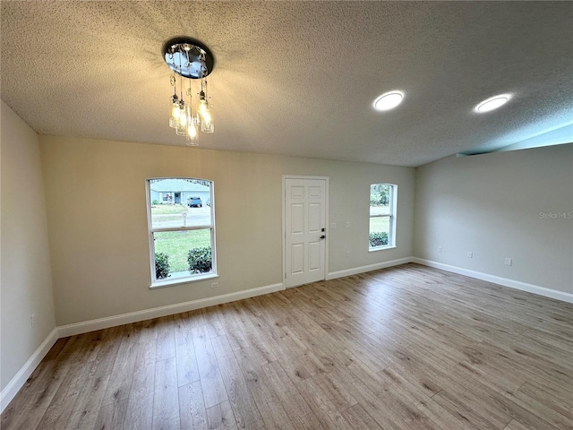 unfurnished room featuring light hardwood / wood-style floors and a textured ceiling