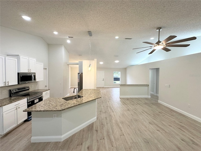 kitchen with appliances with stainless steel finishes, a textured ceiling, a kitchen island with sink, sink, and white cabinets