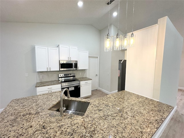 kitchen featuring sink, decorative light fixtures, decorative backsplash, white cabinets, and appliances with stainless steel finishes