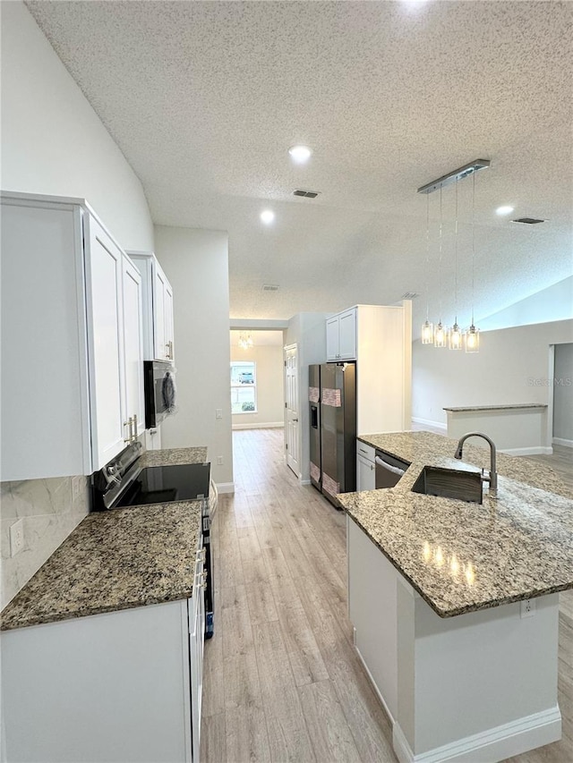 kitchen with white cabinetry, sink, a textured ceiling, decorative light fixtures, and appliances with stainless steel finishes