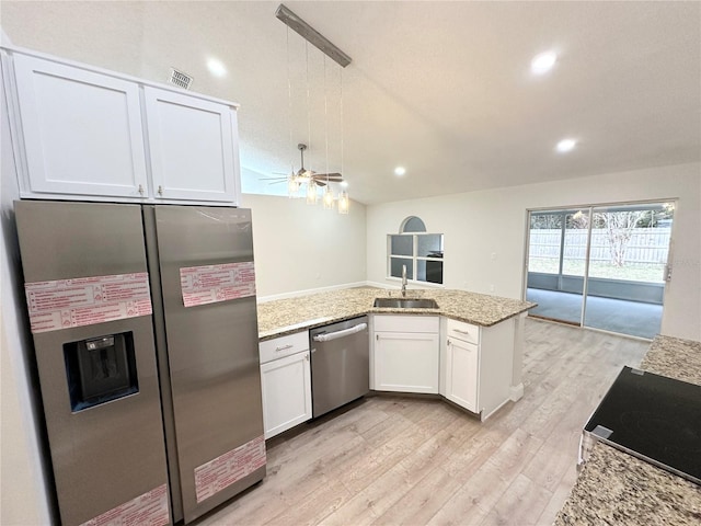 kitchen with light stone countertops, stainless steel appliances, ceiling fan, sink, and white cabinetry