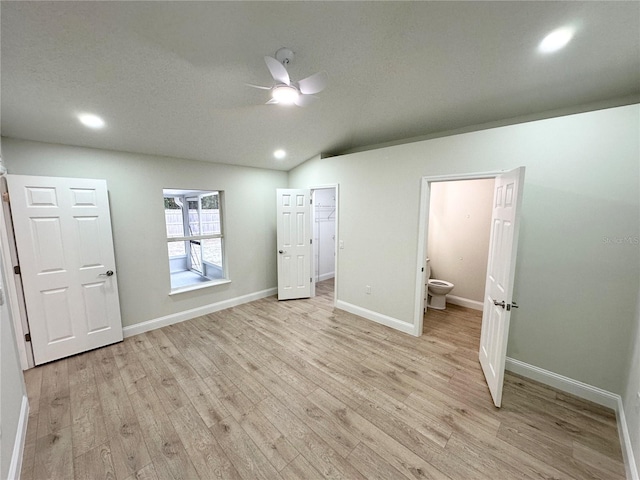 unfurnished bedroom with ensuite bathroom, ceiling fan, light hardwood / wood-style floors, and vaulted ceiling