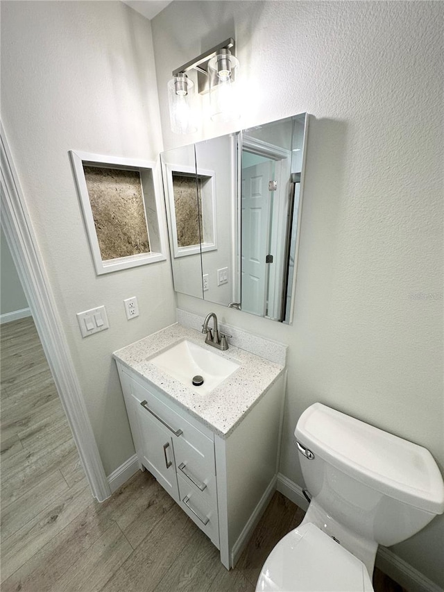 bathroom featuring hardwood / wood-style floors, vanity, and toilet