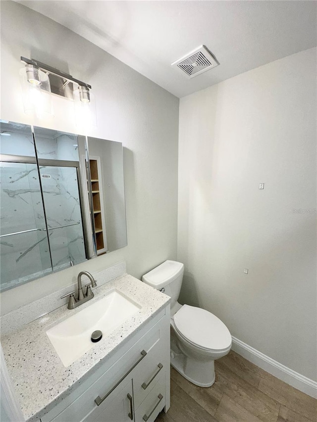 bathroom featuring vanity, wood-type flooring, and toilet