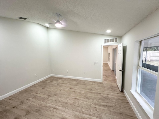 empty room with ceiling fan, light hardwood / wood-style floors, and a textured ceiling