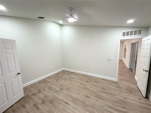 unfurnished room featuring ceiling fan, light hardwood / wood-style floors, and a textured ceiling