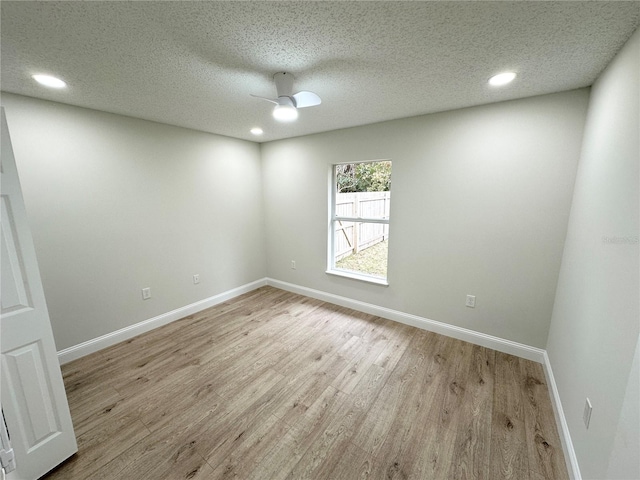 empty room featuring ceiling fan, light hardwood / wood-style floors, and a textured ceiling