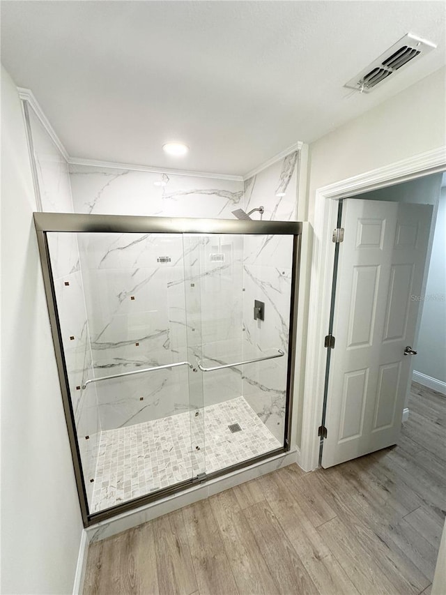 bathroom with hardwood / wood-style floors and an enclosed shower