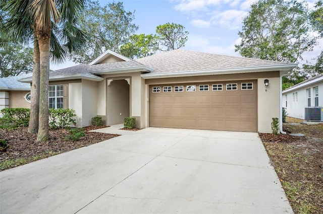 view of front of home with central AC and a garage