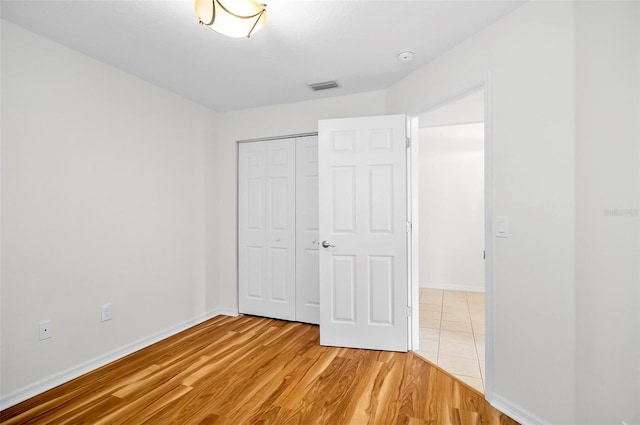 unfurnished bedroom featuring hardwood / wood-style floors and a closet