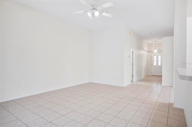 tiled empty room featuring ceiling fan