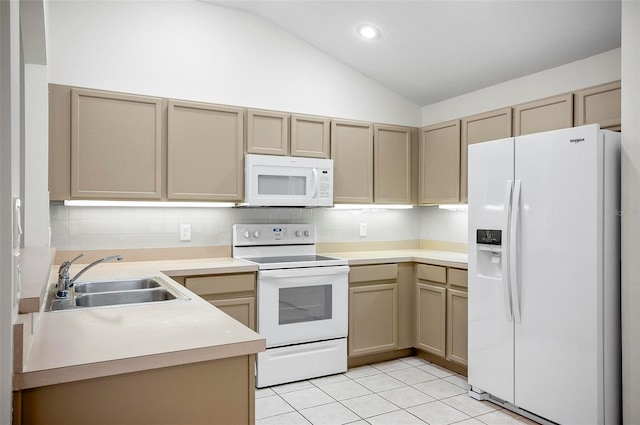 kitchen with white appliances, vaulted ceiling, sink, light tile patterned floors, and light brown cabinets