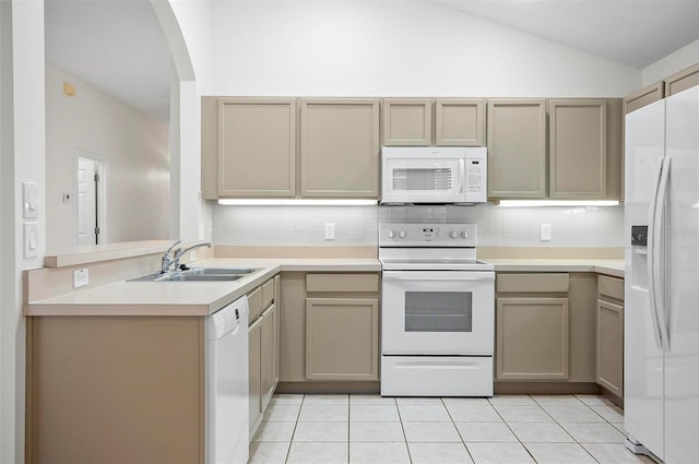 kitchen with white appliances, sink, vaulted ceiling, tasteful backsplash, and light tile patterned flooring