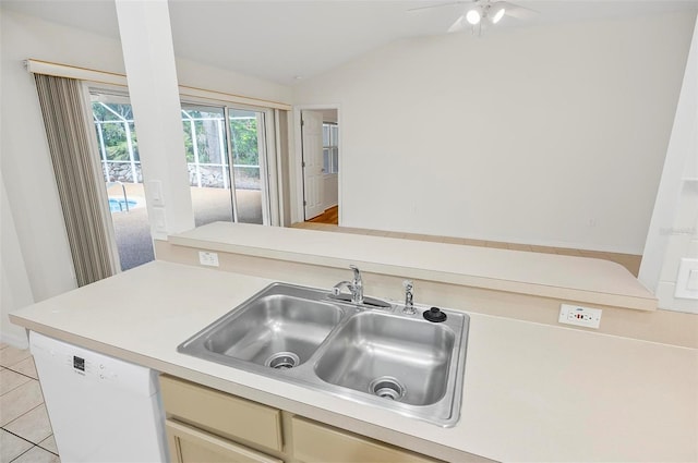 kitchen with white dishwasher, sink, vaulted ceiling, light tile patterned floors, and kitchen peninsula