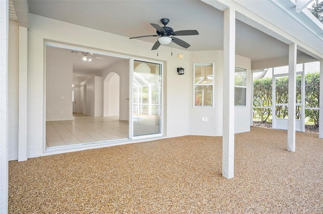 unfurnished sunroom featuring ceiling fan