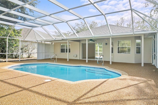 view of pool featuring glass enclosure, ceiling fan, and a patio