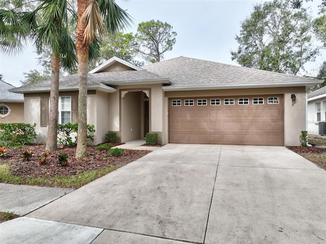 view of front of property featuring a garage and central AC