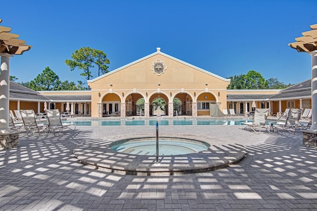 view of swimming pool featuring a patio and a hot tub