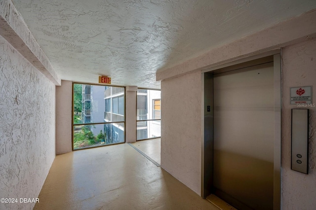 hall featuring expansive windows and elevator