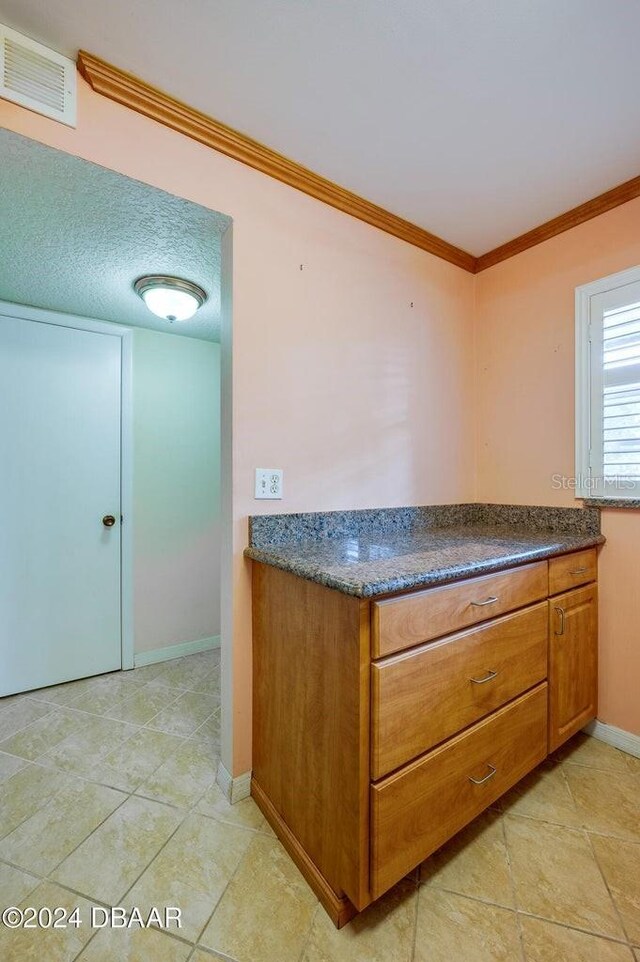 kitchen with crown molding and a textured ceiling