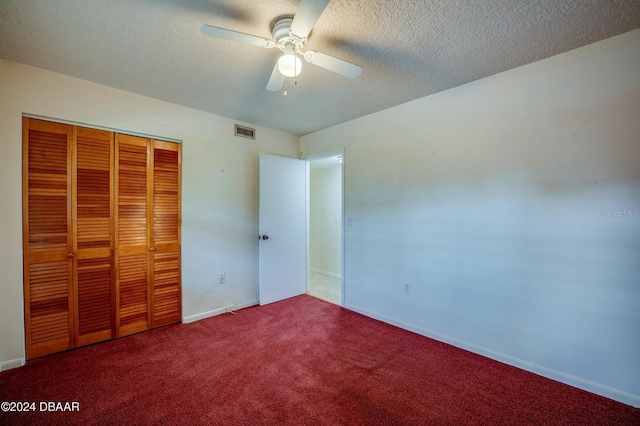 unfurnished bedroom featuring carpet flooring, ceiling fan, a textured ceiling, and a closet