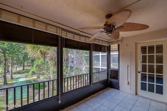 unfurnished sunroom with ceiling fan