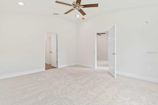 empty room with light carpet, vaulted ceiling, and ceiling fan