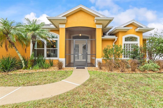 property entrance with a yard and french doors